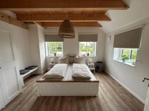 费马恩Linnebarg Hus 2的带一张床和两扇窗户的卧室