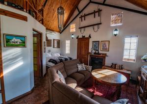 a living room with a couch and a table at Rietpoort Cottage in Parys