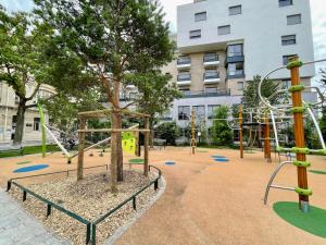 een lege speeltuin met een boom en glijbanen bij New fully equiped appartment with parking in Saint-Mandé