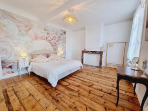 una camera da letto con un letto e un dipinto sul muro di Maison de maître avec jardin, baby-foot, proche de Cassel et plages du Nord, tout inclus ! - FR-1-510-220 a Arnèke