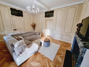 un soggiorno con un divano e un tavolo di Maison de maître avec jardin, baby-foot, proche de Cassel et plages du Nord, tout inclus ! - FR-1-510-220 a Arnèke