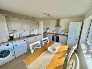 a kitchen with a wooden table and a white refrigerator at Coppice Farm House in Harrogate