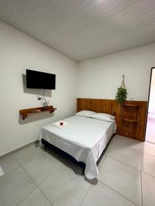 a bedroom with a bed and a flat screen tv at Vento Leste Suites in Flecheiras +19 photos