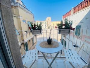 a white table and chairs on a balcony at Casa Larghetto in Ruvo di Puglia