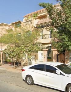 ドバイにあるStylish 3-bedroom plus Maid room - Villa in JVC - Dubaiの建物前に駐車した白車