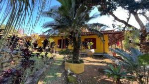 a yellow house with a palm tree in front of it at Pousada Pineiro in Paraty +45 photos