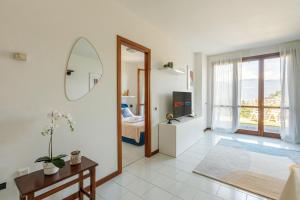 a living room with a mirror and a television at "Panorama sul Lago" Lake Maggiore, Free Wifi Netflix and Tennis in Brezzo
