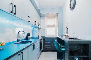 a blue kitchen with a sink and a counter at Deluxe in Valea Lupului