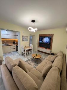 a living room with a large couch and a table at Downtown Deluxe Apartment in Shkodër