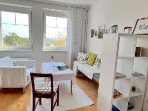 a white living room with a couch and a table at Appartment Weitblick in Eisenstadt