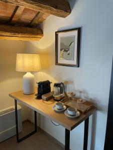 a table with a coffee maker and a lamp on it at Palazzo Zurloni in Revine Lago