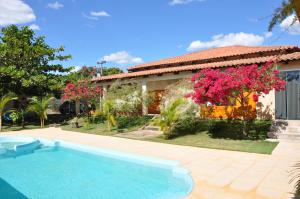 a house with a swimming pool in front of a house at Pousada Suites Bougainville in Cavalcante