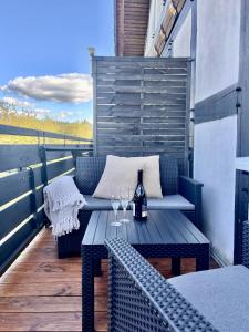 eine Terrasse mit einem Holztisch und Weingläsern in der Unterkunft Apartment No 307 in Küstelberg - 7 min bis Winterberg - Skifahren - Wandern - Erholen in Medebach