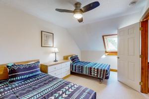 Un dormitorio con dos camas y un ventilador de techo. en Saltbox 12A, en White River Junction