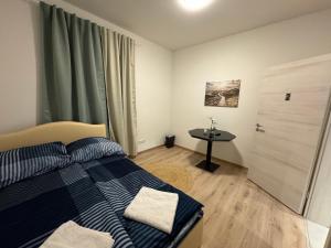 a bedroom with a blue and white bed and a table at City Ferien Wohnungen 2 in Rosenheim