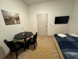 a room with a table and a bed and a table and chairs at City Ferien Wohnungen 2 in Rosenheim +1 photo