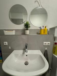 a bathroom with a white sink and a mirror at City Ferien Wohnungen 2 in Rosenheim
