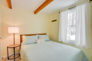 a bedroom with a bed and a window at Cozy Tuftonboro Home with Deck - Walk to Beaches! in Center Tuftonboro