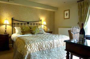 a bedroom with a bed and a table with wine glasses at Whitley Hall Hotel in Chapeltown