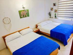 two beds in a small room with blue sheets at Apartamento 3 Dormitorios a solo 1 calle del Mar ツ in Puerto de Gaira