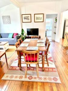 un salon avec une table et des chaises en bois dans l'établissement Yamba Fishing Cottage Haven Wifi boat parking, à Yamba