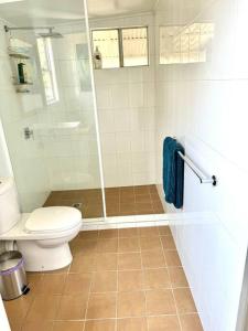 une salle de bain avec toilettes et douche dans l'établissement Yamba Fishing Cottage Haven Wifi boat parking, à Yamba 6 autres photos