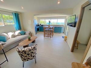 a living room with a couch and a table at Appartement Happy View - Vue mer paradisiaque - Jacuzzi in Friar's Bay