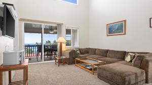 una sala de estar con un sofá y una mesa en Alii Cove Y22, en Kailua-Kona
