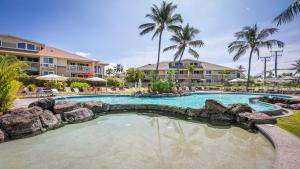 una piscina en un resort con palmeras en Alii Cove Y22, en Kailua-Kona