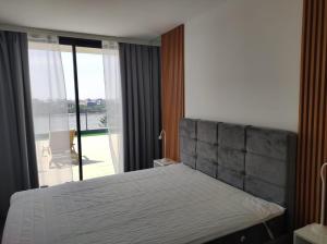 a bedroom with a bed and a large window at Kaskade Hill Apartments in Novi Sad