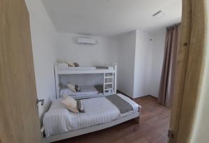 Un dormitorio con una cama blanca con almohadas. en complejo OHANA, en Potrero de los Funes