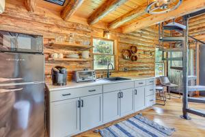 a kitchen with white cabinets and a stainless steel refrigerator at Peaceful Creekside North Studio with Fire Pit in Holmesville +17 photos