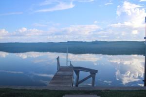 a dock on a lake with a reflection of the sky at Pool with Canal views Minutes 2 beach BBQ Pit in Padre Island
