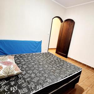 a bedroom with a bed with a blue head board at Lar na Praia in Praia Grande +15 photos