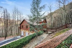 a wooden house in the middle of a forest at Round Top Way Cabin By Beyond Expectations in Sevierville