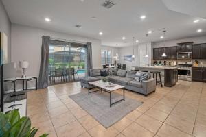 un soggiorno e una cucina con un divano e un tavolo di Lazy River Game Room heated pool 10Mi to Disney a Davenport