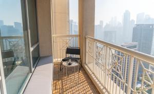 a chair sitting on the balcony of a building at Downtown Oasis, Burj Khalifa Views, Luxury Amenities in Dubai