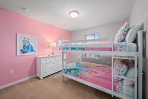 una camera con pareti rosa e bianche e letti a castello di Lazy River Game Room heated pool 10Mi to Disney a Davenport