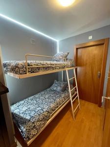 Dos literas en una habitación con puerta. en Mi Casita en la Sierra, en Sierra Nevada