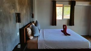 a bedroom with a bed with a red shoe on it at Than Prawet Waterfall villa in Thong Nai Pan Noi +7 photos