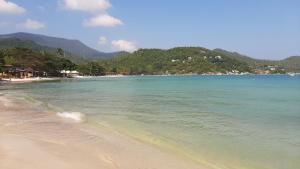 a beach with the ocean and mountains in the background at Than Prawet Waterfall villa in Thong Nai Pan Noi