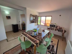a dining room with a table and green chairs at Vila Khalo in Mangalia
