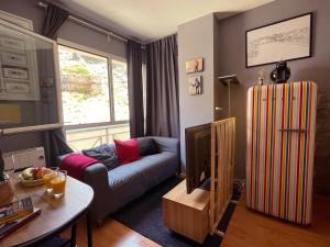 Una sala de estar con un sofá y un televisor. en Mi Casita en la Sierra, en Sierra Nevada