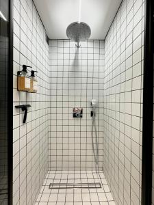 ビアリッツにあるVictoria Surf Studio d'Architecteの白いタイル張りの壁のバスルーム(シャワー付)