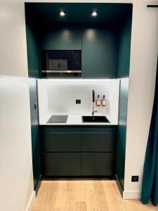 ビアリッツにあるVictoria Surf Studio d'Architecteのキッチン(緑と白のキャビネット、電子レンジ付)