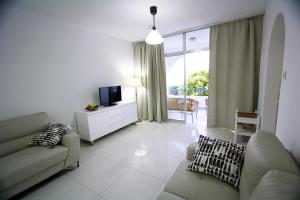 a living room with a couch and a tv in it at Pissouri Beach Apartments in Pissouri