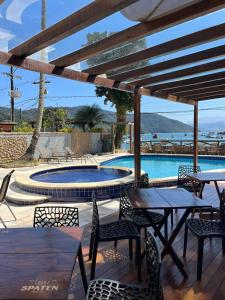 a patio with tables and chairs and a swimming pool at Pousada do Canto in Abraão