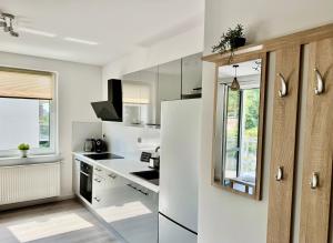 a white kitchen with a sink and a refrigerator at Przystanek Skarpa in Olsztyn