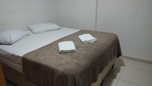 Una cama con dos toallas encima en Apartamento centro, en Ubá