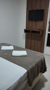 Un dormitorio con una cama con dos toallas blancas. en Apartamento centro, en Ubá